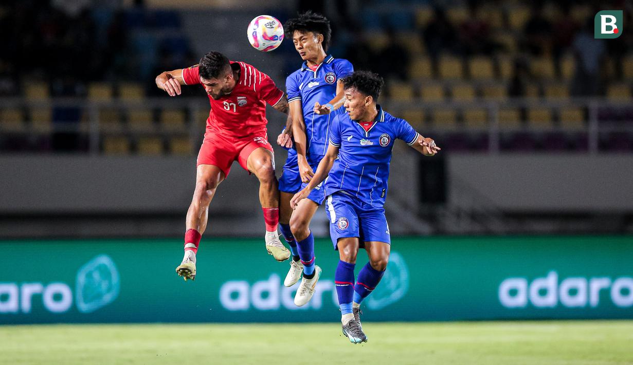 <p>Pemain Arema FC, Achmad Maulana Syarif (tengah) berduel udara dengan pemain Borneo FC, Berguinho pada laga final Piala Presiden 2024 di Stadion Manahan, Solo, Minggu (4/8/2024). (Bola.com/Bagaskara Lazuardi)</p>