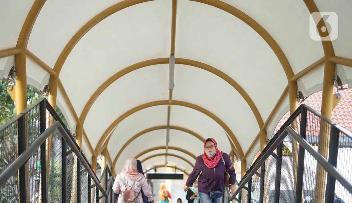 Warga melitasi Jembatan Penyeberangan Orang (JPO) di depan Stasiun Pasar Minggu, Jakarta, Kamis (9/1/2020). JPO yang juga dilengkapi dengan penutup dan lampu warna-warni tersebut menghubungkan Stasiun Pasar Minggu dengan pasar tradisional Pasar Minggu. (Liputan6.com/Immanuel Antonius)