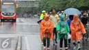Sejumlah warga mengenakan jas hujan saat mengikuti kegiatan Car Free Day, Jakarta, Minggu (24/1/2016). Meski hujan mengguyur Ibu Kota sejak semalam, kegiatan CFD pagi di kawasan Bundaran Hotel Indonesia masih tetap ramai. (Liputan6.com/Helmi Affandi)