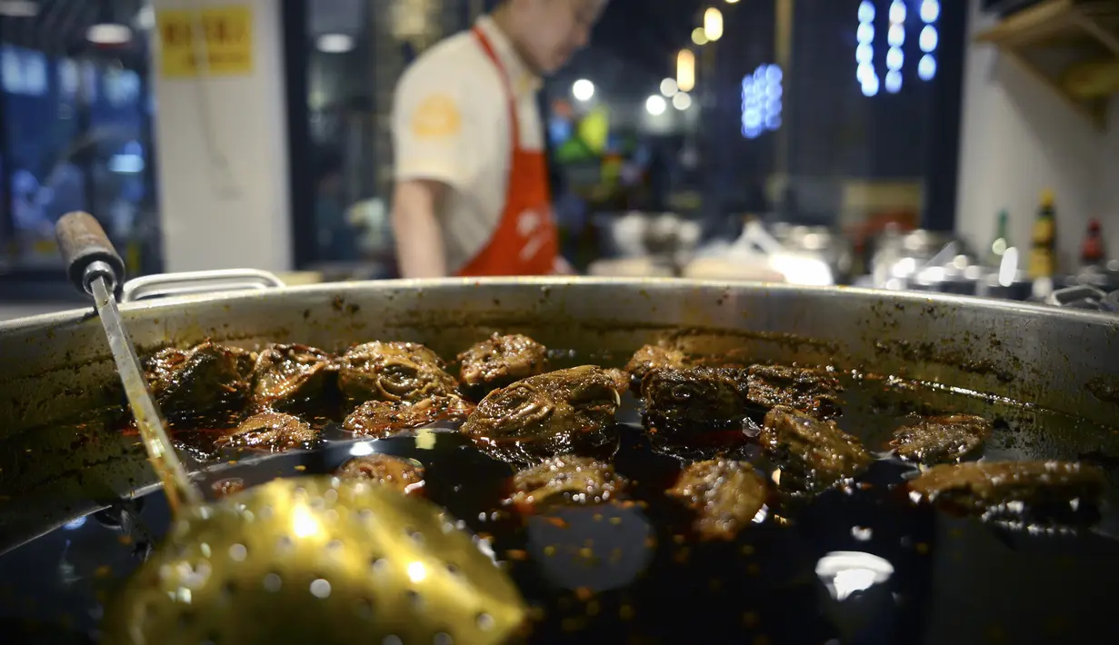 Koki menyiapkan menu kepala kelinci di sebuah restoran di Chengdu, ibu kota Provinsi Sichuan di barat daya China, 8 September 2016. Otak kelinci di negeri tirai bambu ini menjadi salah satu menu favorit warga lokal maupun asing. (WANG ZHAO/AFP)