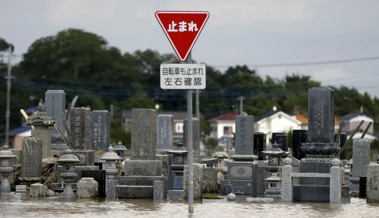 Sebuah pemakaman terendam air akibat meluapnya sungai Kinugawa yang disebabkan Topan Etau di Joso, Ibaraki Prefecture, Jepang, Sabtu (12/9/2015). Tim evakuasi terus melakukan pencarian terhadap warga yang terkena dampak Topan Etau.  (REUTERS/Issei Kato)