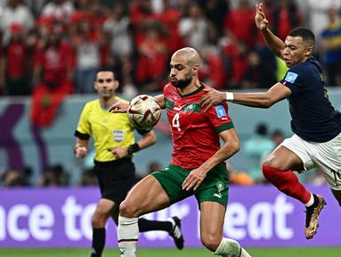 Pemain Maroko, Sofyan Amrabat (kiri) berebut bola dengan pemain Prancis, Kylian Mbappe pada laga semifinal Piala Dunia 2023 Qatar di Al-Bayt Stadium, Al Khor, 4 Desember 2022. Amrabat bergabung dengan Manchester United pada bursa transfer musim panas 2023/2024 dengan status pinjaman dari Fiorentina. (AFP/Gabriel Bouys)