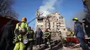 Satu gedung terbakar, sementara lantai atas bangunan lainnya hancur total. Tampak dalam foto, petugas penyelamat memadamkan kebakaran di sebuah gedung perumahan yang rusak akibat serangan Rusia di Ternopil, Ukraina, pada Rabu 19 November 2025. (AP Photo/Rostyslav Kovalchuk)