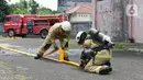 Peserta lomba Jakarta Fire and Rescue Competition 2022 di Pusdiklat Gulkarmat, Ciracas, Jakarta Timur, Senin (21/3/2022). Lomba tersebut untuk menguji ketangkasan dan kecepatan petugas dalam proses penyelematan korban kebakaran di atas gedung dan di air. (Liputan6.com/Herman Zakharia)