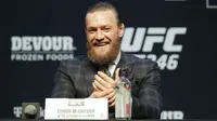 Conor McGregor tersenyum saat konferensi pers untuk pertarungan seni bela diri campuran UFC 246 melawan Donald "Cowboy" Cerrone di Las Vegas (15/1/2020). Duel McGregor dan Cerrone jadi pertarungan non-gelar kelas welter UFC. (AP Photo/John Locher)