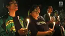 Gabungan suporter klub sepak bola memanjatkan doa sambil menyalakan lilin dalam aksi solidaritas terkait tragedi teror bom di Surabaya dan Sidoarjo di Taman Suropati, Jakarta, Senin (14/5). (Liputan6.com/Immanuel Antonius)