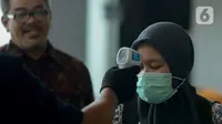 Pekerja menjalani pemeriksaan suhu tubuh di salah satu perkantoran di Jakarta, Selasa (3/3/2020). Pemeriksaan suhu tubuh tersebut untuk mengantisipasi penyebaran virus corona atau COVID-19 di lingkungan kerja. (merdeka.com/Imam Buhori)
