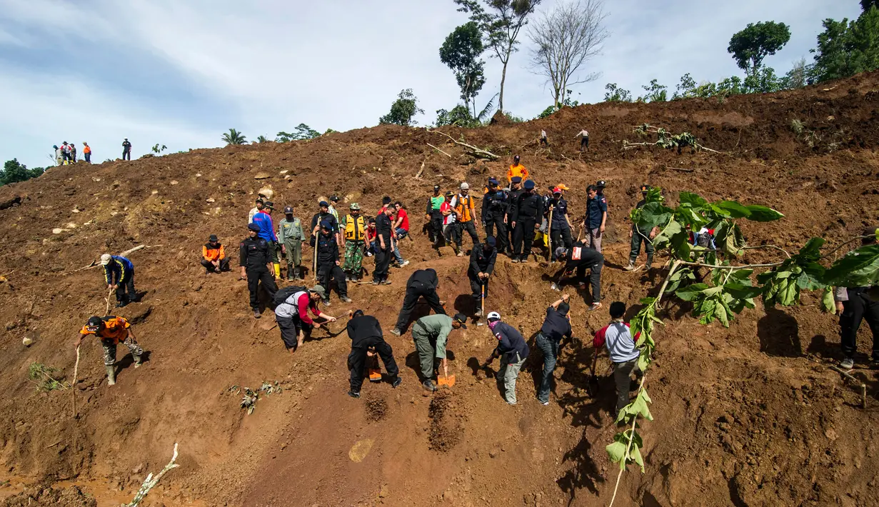 Petugas penyelamat melakukan pencarian terhadap korban longsor di Kabupaten Ponorogo, Jawa Timur, Minggu (2/4). Alat berat dan anjing pelacak diterjunkan untuk mencari puluhan korban yang masih hilang tertimbun dalam material longsor. (JUNI KRISWANTO/AFP)