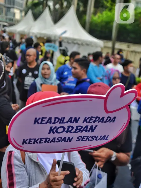 Masyarakat membawa poster sosialisasi UU TPKS saat Car Free Day di kawasan Bundaran HI, Jakarta, Minggu (25/9/2022). Kampanye Undang-undang Tindak Pelaku Kekerasan Seksual (UU TPKS)  tersebut dilakukan agar masayarakat dapat mengetahui UU ini menjadi payung hukum bagi korban kekerasan seksual. Bukan hanya korban yang bisa melaporkan tindak kekerasan seksual, tapi bagi yang mendengar atau melihat juga bisa melaporkan. (Liputan6.com/Angga Yuniar)