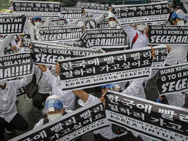 Massa calon pekerja migran Indonesia membawa poster memadati badan jalan Gatot Subroto, berunjuk rasa di depan kompleks Kemenaker, Jakarta, Senin (18/10/2021). Aksi dilakukan untuk menuntut kejelasan status penempatan mereka. (Liputan6.com/Faizal Fanani)