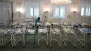 Perawat merawat bayi yang baru lahir dari skema ibu pengganti (surrogate mother) di Hotel Venice, Kiev, Ukraina, 15 Mei 2020. Sekitar 100 bayi yang lahir dari skema ibu pengganti telantar di Ukraina. (Sergei SUPINSKY/AFP)