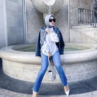 Syahrini tampil casual dengan kemeja putih dan luaran jaket kulit hitam dipadukan celana senim. Handbag dan heels putih dari Belenciaga seharga Ro13 juta melengkapi gayanya.(@princessyahrini)