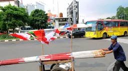 Selain mangkal di tepian jalan, pedagang bendera itu ada pula yang menjajakan dengan cara keliling mendorong gerobak, Minggu (3/8/14). (Liputan6.com/Faisal R Syam)