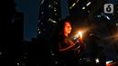 Karyawan menyalakan lilin di kawasan SCBD, Jakarta, Sabtu (25/3/2023). (Liputan6.com/Angga Yuniar)