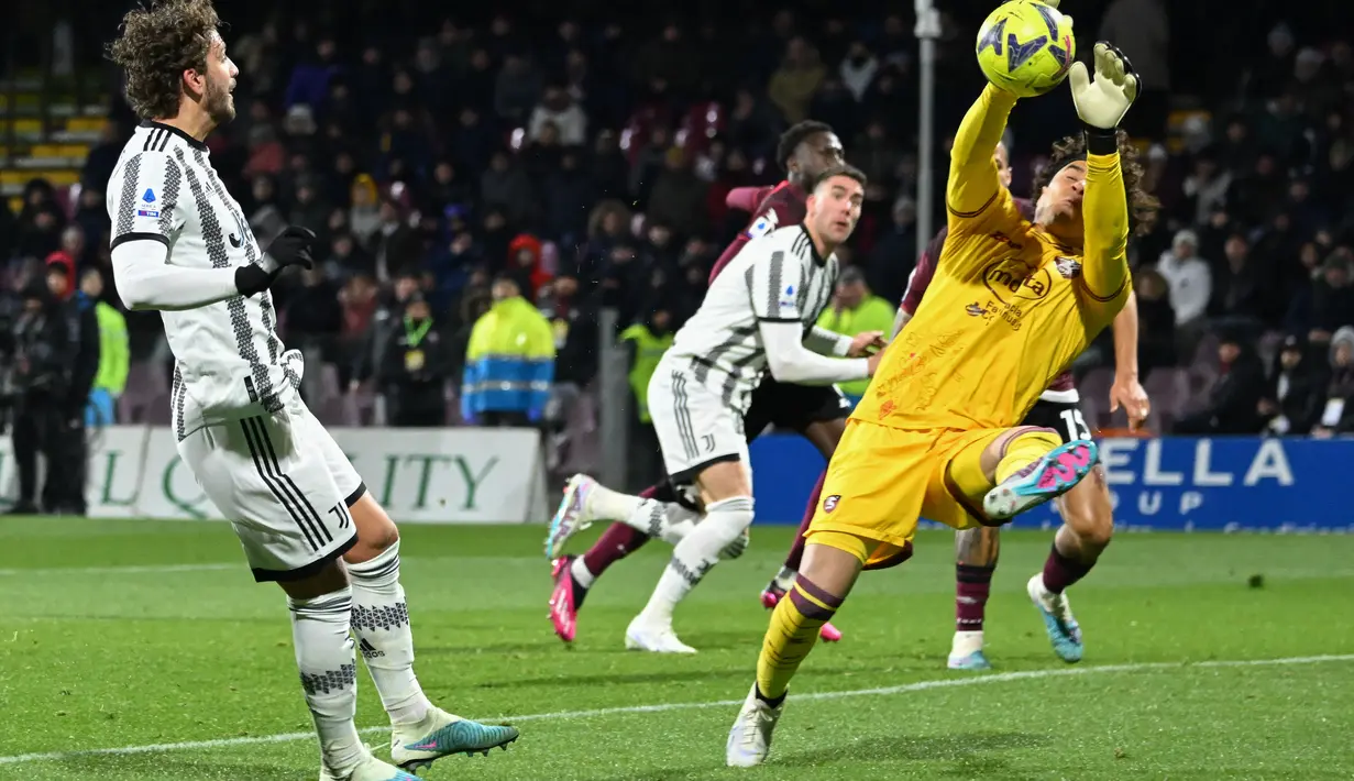 Gelandang Juventus Manuel Locatelli (Kiri) menantang kiper Salernitana Guillermo Ochoa pada pekan ke-21 Liga Italia 2022/2023 di Stadio Arechi, Rabu dini hari WIB (8/2/2023).  Juventus terhindar dari potensi mendekati zona degradasi usai meraih kemenangan dalam laga ini. (Photo by Andreas SOLARO / AFP)