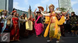 Peserta pawai budaya memperingati Hari Internasional Masyarakat Adat se-Dunia menari di Bundaran HI, Jakarta, Minggu (7/8). (Liputan6.com/Angga Yuniar)