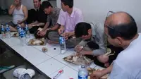 WNA asal Afghanistan menyantap makan malam di ruang tahanan Rumah Detensi Imigrasi Depkumham Jatim. Belasan imigran tersebut ditangkap di Perairan Sidoarjo. (Antara)