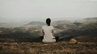 Ilustrasi wanita sedang menenangkan pikiran dengan duduk dan melihat pemandangan alam perbukitan (Unsplash/Milan Popovic)