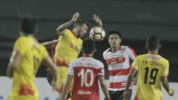 Bek Bhayangkara FC, Paulo Sergio, duel udara dengan pemain Madura United pada laga lanjutan liga 1 di Stadion Patriot, Bekasi, kamis (13/7/2017). Bhayangkara FC menang 2-1 atas Madura United. (Bola.com/M Iqbal Ichsan)