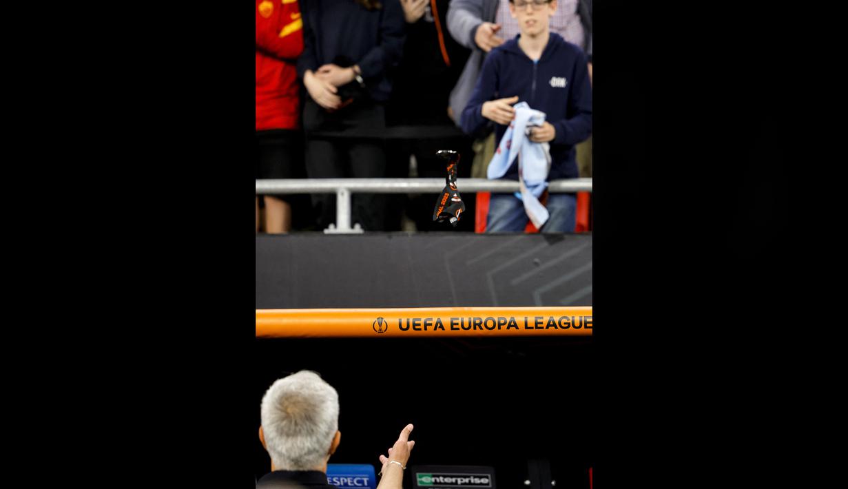 Pelatih AS Roma, Jose Mourinho memberikan medali kepada suporter setelah pertandingan final Liga Europa 2022/2023 yang berlangsung di Stadion Puskas Arena, Hungaria, Jumat (01/06/2023) dini hari WIB. (AFP/Odd Andersen)