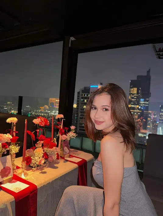 Selain dekorasi meja makan yang dipenuhi bunga-bunga, suasana dinner kian romantis dengan penampilan serasi pasangan ini. [@sandrinna_11].