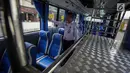 Petugas mengecek kondisi dalam bus Transjabodetabek Premium milik Perum PPD saat menunggu calon penumpang di Tamini Square, Jakarta, Kamis (14/12). (Liputan6.com/Faizal Fanani)