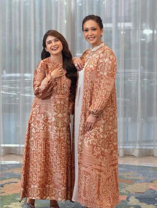 Meski tak sedarah, Maia Estianty dan Tissa Biani seperti ibu dan anak yang kompak. Keduanya serasi mengenakan gamis warna orange bermotif floral. [@geulis.id]