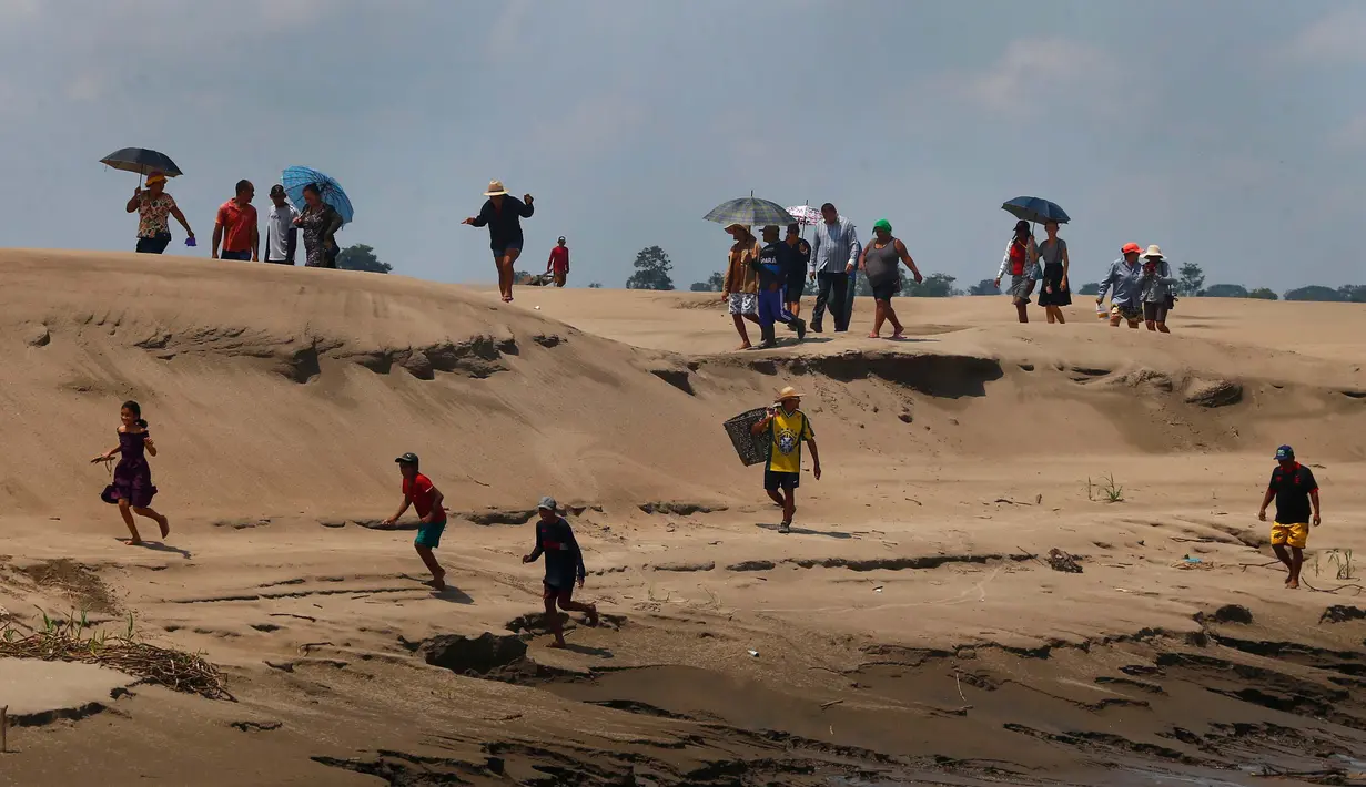Masyarakat tepi sungai antre untuk menerima pasokan air dan makanan selama aksi bantuan kemanusiaan negara bagian karena kekeringan dan suhu tinggi yang sedang berlangsung yang mempengaruhi wilayah sungai Solimoes, Careiro da Varzea, negara bagian Amazonas, Brasil, Selasa, 24 Oktober 2023. (AP Photo/Edmar Barros)