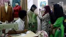 Pelanggan mencoba baju pesanannya yang dijahit di Pasar Mayestik, Jakarta Selatan, Senin (11/6). Masyarakat mulai membeli dan membuat baju pilihan mereka jelang Lebaran. (Liputan6.com/JohanTallo)