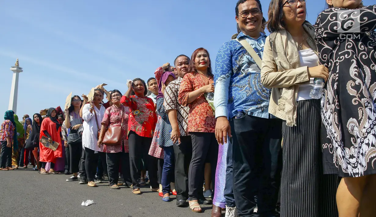 Warga mengantre di kawasan Silang Monas, untuk mengikuti Open House Jokowi di Istana Kepresidenan, Jakarta Rabu (5/6/2019). Antrean warga sejak pagi hari terlihat mengular hingga lebih dari 20 meter di pintu sebelah barat Monas. (Liputan6.com/HO/Grandy)
