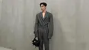 Lee Jae Wook mengenakan oversized suit berwarna abu-abu tua. Dia melengkapi penampilannya dengan tas berwarna hitam. (Foto: Instagram/ jxxvvxxk)