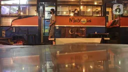 Penampakan kafe yang menggunakan angkutan metromini di Bekasi, Jawa Barat, Kamis (15/4/2021). Kafe ini berinovasi di tengah pandemi COVID-19 dengan menggunakan armada metromini yang sudah tidak terpakai sebagai tempat makan pengunjung. (Liputan6.com/Herman Zakharia)