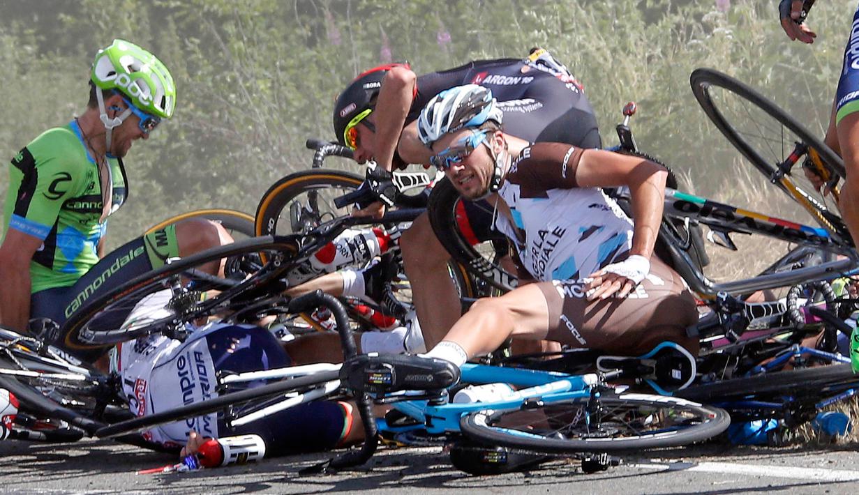 Seorang pebalap tampak tertindih sepedanya usai insiden kecelakaan yang melibatkan puluhan pebalap sepeda saat babak ketiga Tour de France dari Anvers ke Huy di Belgia, Senin (6/7/2015). (REUTERS/Eric Gaillard)