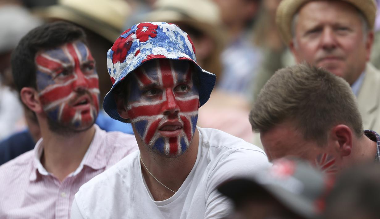 Beberapa suporter dengan wajah bergambar bendera Inggris hadir mendukung Andy Murray  saat melawan Sam Querrey pada perempat final Wimbledon 2017 di The All England Lawn Tennis Club, London, (12/7/2017). (AFP/Daniel Leal-Olivas)