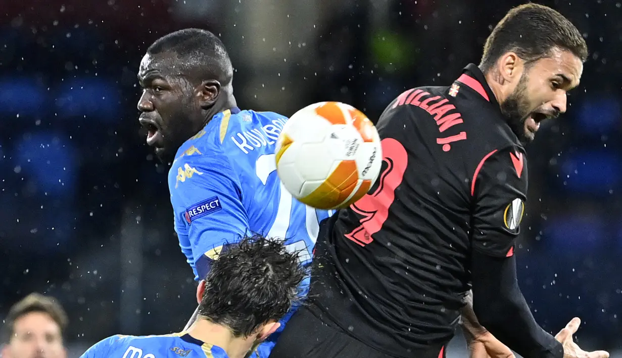 (Dari kiri) Bek Napoli Mario Rui, bek Napoli Kalidou Koulibaly dan penyerang Real Sociedad Willian Jose melakukan sundulan pada matchday terakhir Grup F Liga Europa di Diego Armando Maradona, Jumat (11/12/2020) dini hari WIB. Napoli bermain imbang 1-1 melawan Real Sociedad. (Alberto PIZZOLI / AFP)