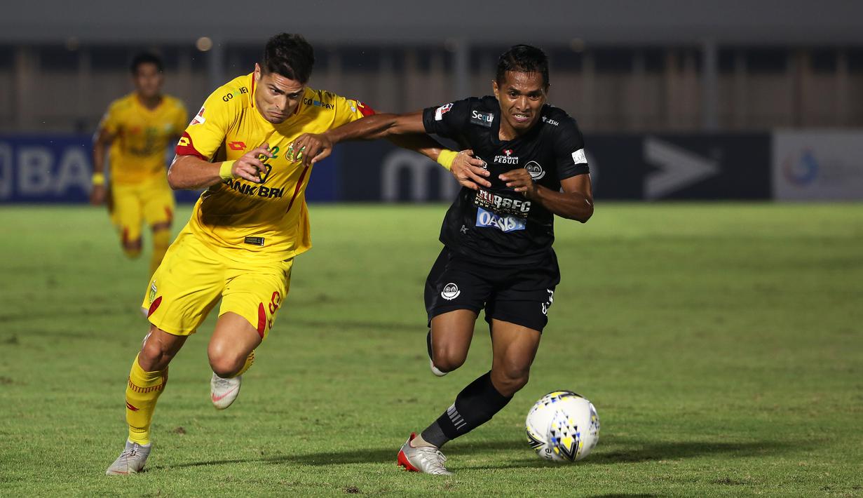 Striker Bhayangkara FC, Ramiro Fergonzi , berebut bola dengan bek Tira Persikabo, Abduh Lestaluhu, pada laga Liga 1 2019 di Stadion Madya, Senayan, Jakarta, Kamis (4/7/2019). Kedua tim bermain imbang 1-1. (Bola.com/Yoppy Renato)