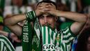 Seorang suporter Real Betis memegang kepalanya sambil meneteskan air mata sebagai bentuk kecewa atas kekalahan timnya dalam laga final UEFA Conference League melawan Chelsea di Tarczynski Arena, Wroclaw, Polandia, Kamis (29/05/2025) dini hari WIB. (AFP/Cristina Quicler)