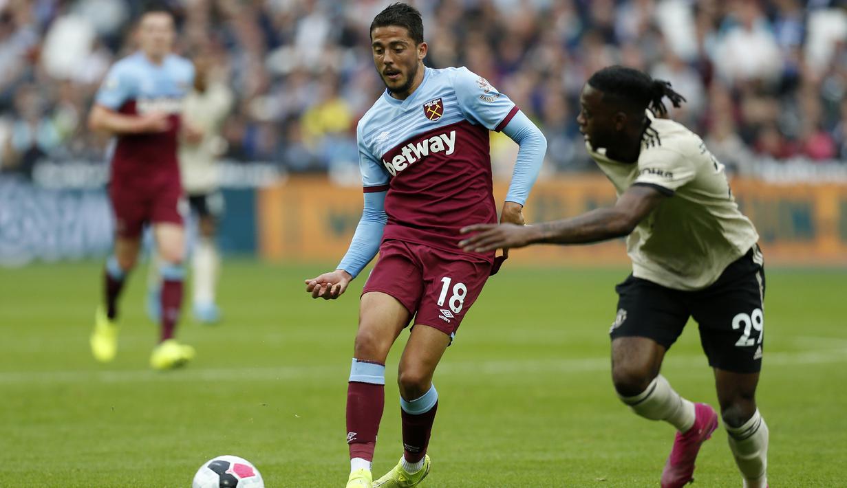 Gelandang West Ham, Pablo Fornals, berusaha melewati bek Manchester United, Aaron Wan Bissaka, pada laga Premier League di Stadion London, London, Minggu (22/9). West Ham menang 2-0 atas MU. (AFP/Ian Kington)