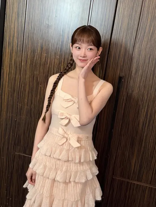 Lee Yoo Mi hadir mengenakan dress ruffle warna nude. Dress sleeveless ini memiliki aksen tiga pita besar di bagian depan. Tampilannya semakin cute dengan gaya kepang dua belakang. [@leeyoum262]