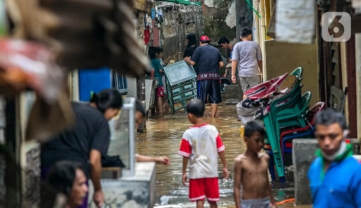 Warga membersihkan barang-barang usai terendam banjir di permukiman kawasan Kampung Melayu, Jakarta, Selasa (9/2/2021). Banjir yang berangsur surut dimanfaatkan warga untuk membersihkan rumah dan barang-barang dari endapan lumpur. (Liputan6.com/Faizal Fanani)
