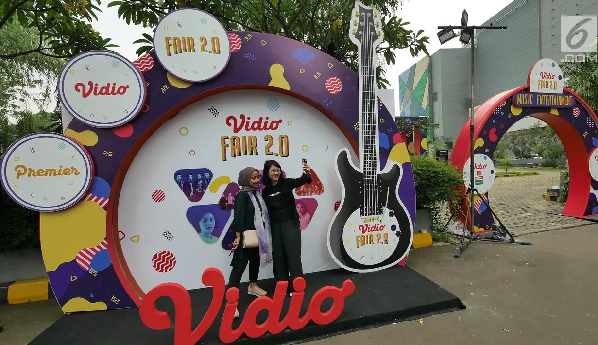 Pengunjung berfoto di booth Vidio Fair 2.0 yang digelar di Mall Gandaria City, Jakarta, Sabtu (3/11). Acara Vidio Fair 2.0 diramaikan dengan berbagai macam kegiatan yang dapat dinikmati oleh pengunjung yang hadir. (Liputan6.com/Herman Zakharia)