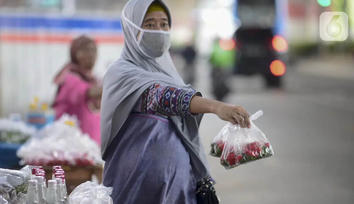 Pedagang menawarkan kembang untuk berziarah di kawasan Gembrong, Prumpung, Jakarta, Kamis (23/4/2020). Jelang Ramadan, pedagang kembang untuk berziarah mengeluhkan sepinya pembeli karena adanya Pembatasan Sosial Berskala Besar (PSBB) untuk mencegah penyebaran COVID-19. (merdeka.com/Imam Buhori)