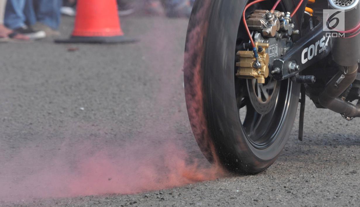 Ban seorang freestyler mengeluarkan asap saat melakukan atraksi freestyle sepeda motor dalam Festival Damai Millenial Road Safety di Monas, Jakarta, Minggu (23/6/2019). Festival ini menyosialisasikan disiplin berlalu lintas serta merajut persatuan dan kesatuan. (merdeka.com/Iqbal Nugroho)