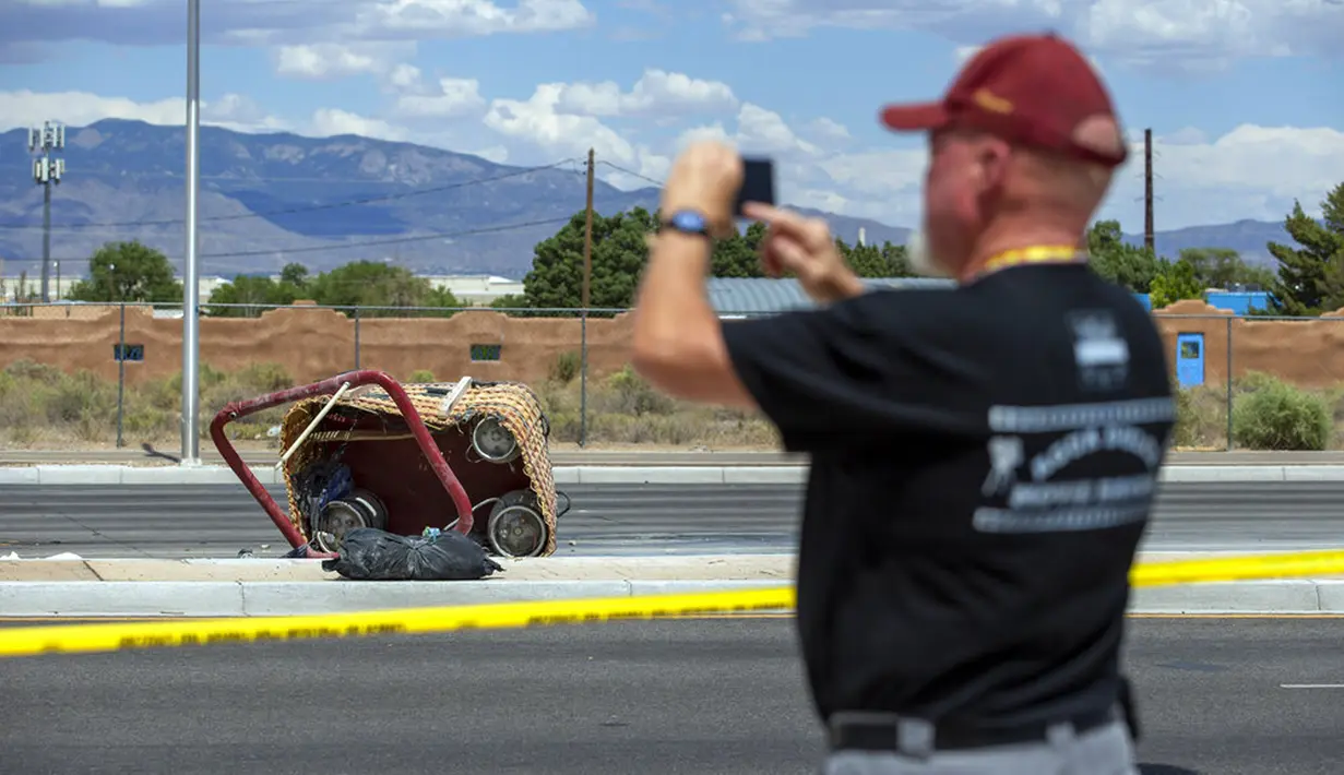 Seorang pejalan kaki mengambil foto keranjang balon udara yang jatuh di Albuquerque, New Mexico, Amerika Serikat, Sabtu (26/6/2021). Manurut sejumlah saksi mata, balon udara jatuh ke tanah dalam keadaan yang benar-benar kempis. (AP Photo/Andres Leighton)