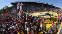 Suporter Ferrari memadati lintasan setelah pebalap Ferrari, Sebastian Vettel, berhasil meraih podium di Sirkuit Monza, Italia. Minggu (6/9/2015). (AFP Photo/Andreas Solaro)