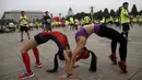 Dua orang peserta meregangkan tubuh mereka jelang mengikuti Beijing International Marathon di Beijing, China, Minggu (20/9/2015). Sekitar 30.000 pelari ikut ambil bagian dalam acara yang berlangsung tiap tahun. (REUTERS/Kim Kyung-Hoon)