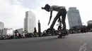 Aksi seorang remaja bermain skateboard di kawasan Bundaran HI Jakarta, Minggu (14/12/2015). (Liputan6.com/Faizal Fanani)
