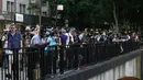 Orang-orang berkumpul untuk mengambil gambar saat matahari terbenam di Manhattan ketika fenomena "Manhattanhenge" di 42nd street, New York, Senin (11/7/2022). Fenomena Manhattanhenge hanyaterjadi di musim panas, tepatnya diantara bulan Mei hingga Juli. (Yuki IWAMURA / AFP)