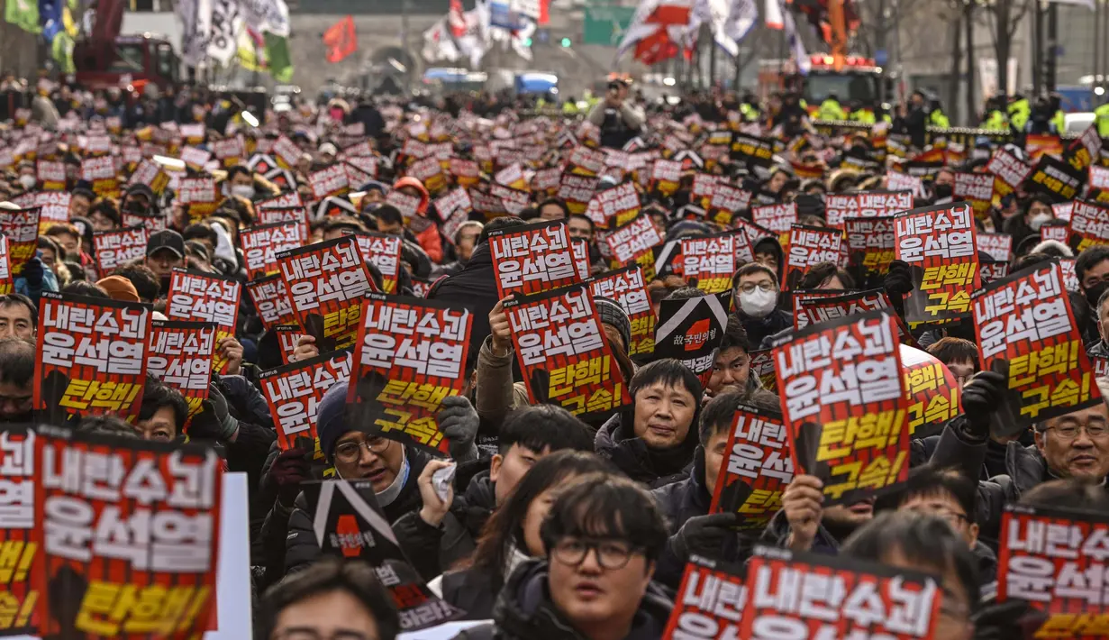 Para demonstran dari kelompok buruh ikut serta dalam unjuk rasa yang digelar di luar Balai Kota, Seoul pada 12 Desember 2024. (ANTHONY WALLACE/AFP)