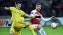 Duel antara Skhordan Mustafi dan Stanislav Dragun pada leg 1,32 besar Liga Europa yang berlangsung di stadion Borisov Arena, Borisov, Jumat (15/2). Arsenal tumbang 0-1 kontra Bate Borisov. (AFP/Sergei Gapon)
